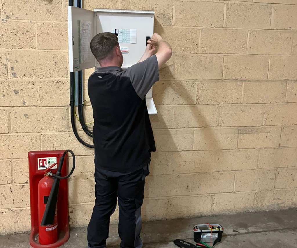 Engineer carrying out scheduled electrical maintenance in a plant room