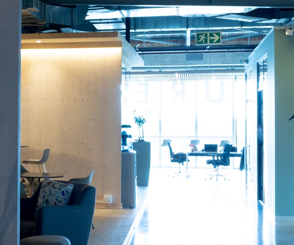 Office corridor lighting with emergency exit sign, supporting safe egress routes