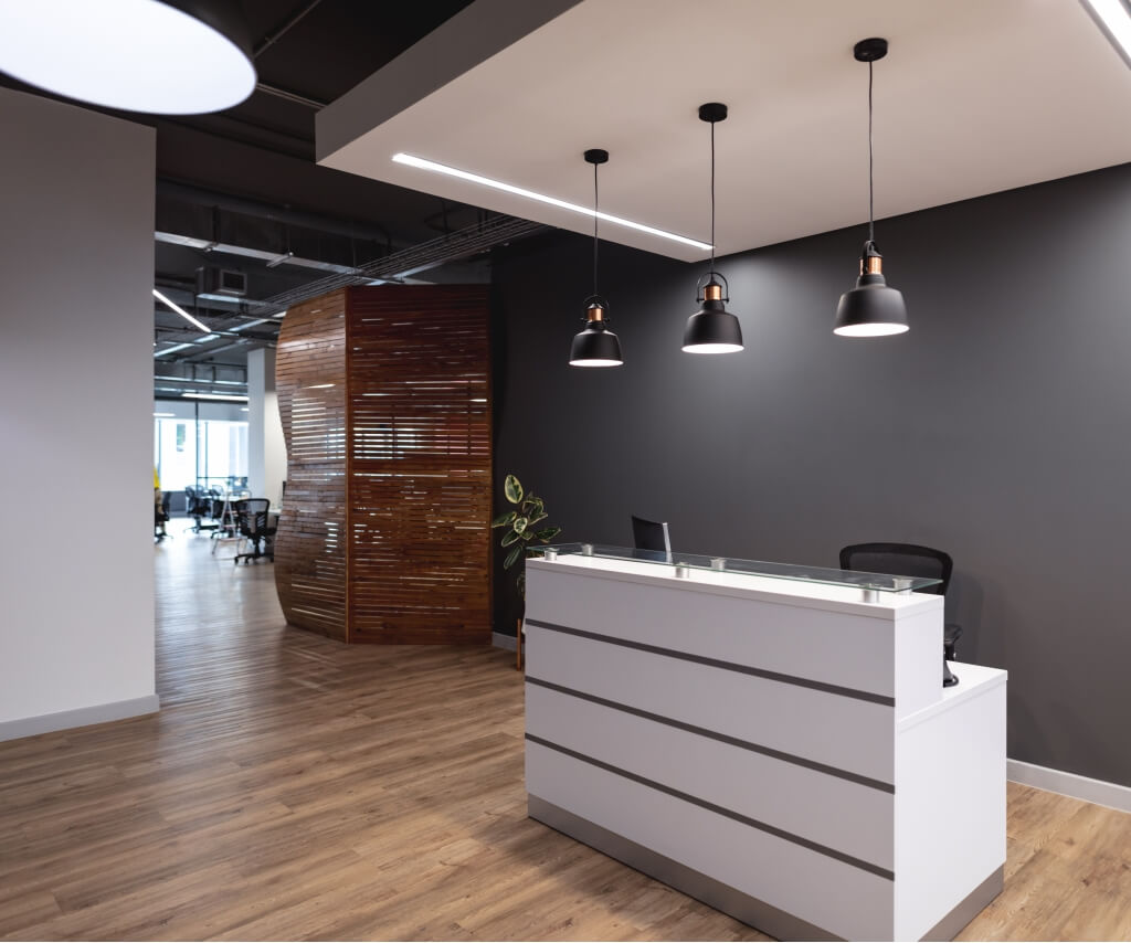 Office reception lighting with pendant LEDs and clean ceiling finishes, welcoming entrance area