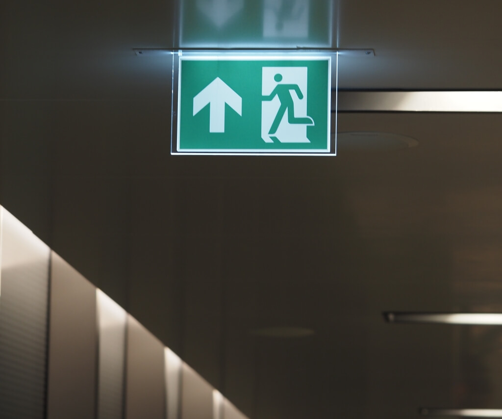 Emergency exit sign in customer area, safe egress route lighting
