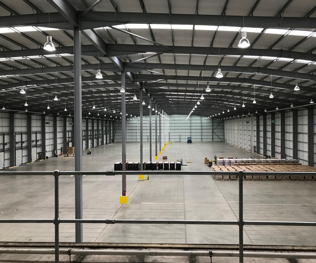 High bay LED lighting in a warehouse, bright even coverage for logistics operations