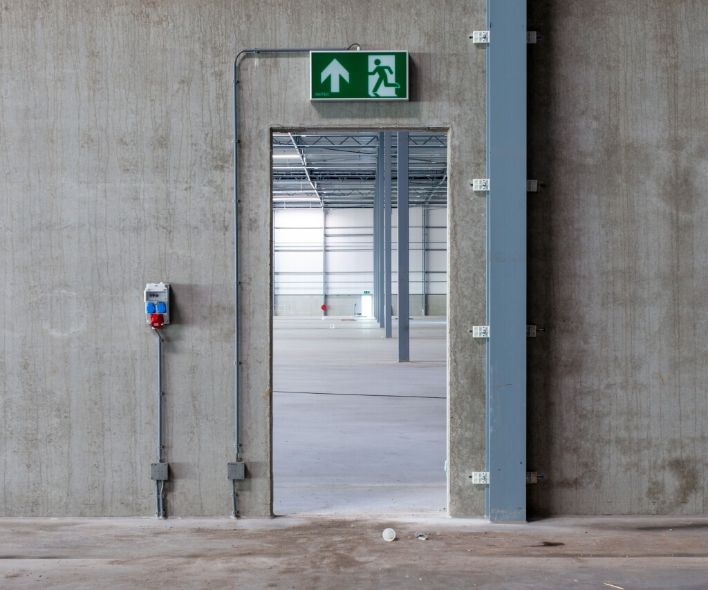 Emergency exit sign and escape route lighting in an industrial warehouse