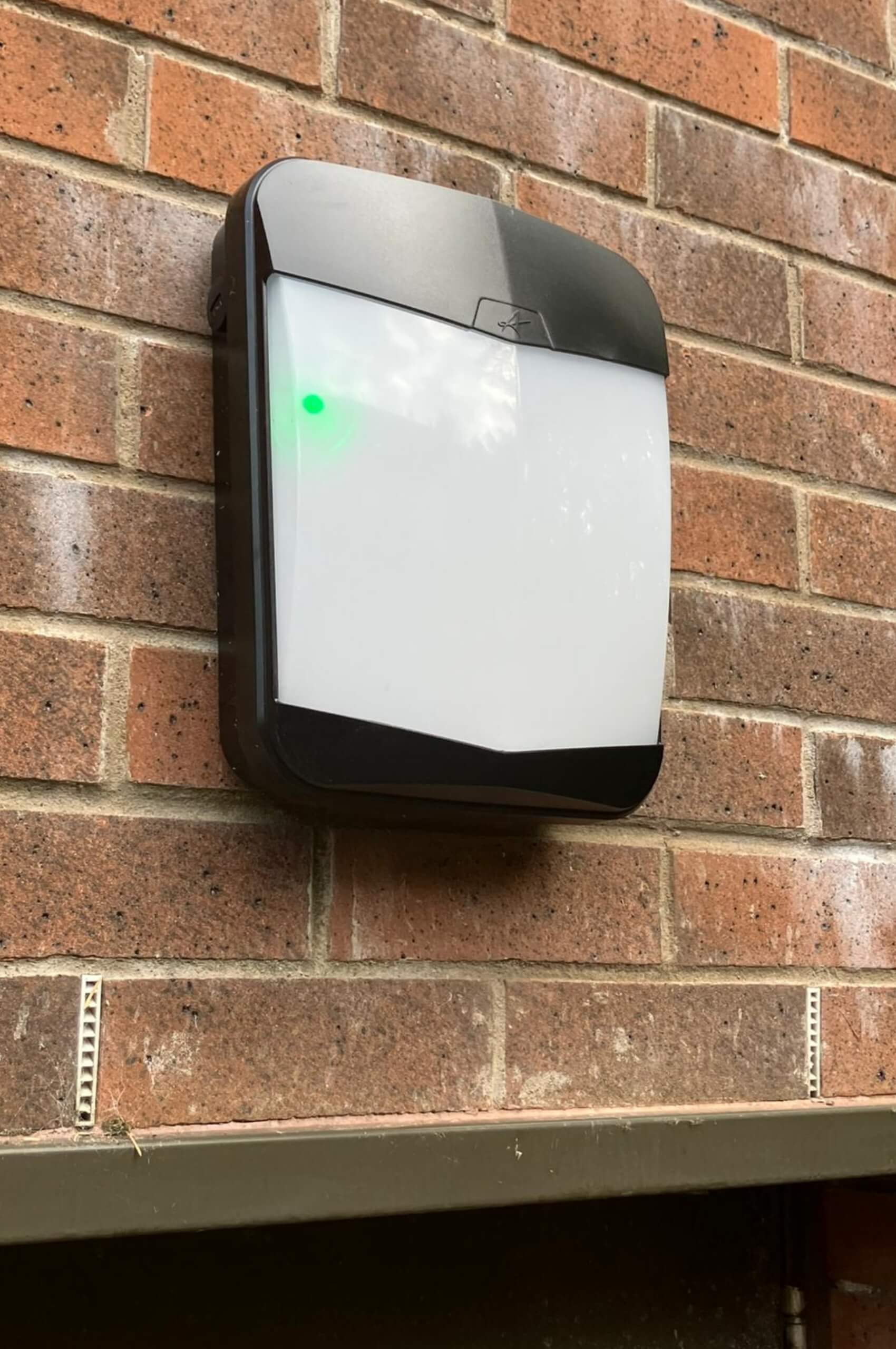 Wall mounted LED bulkhead security light on external brickwork